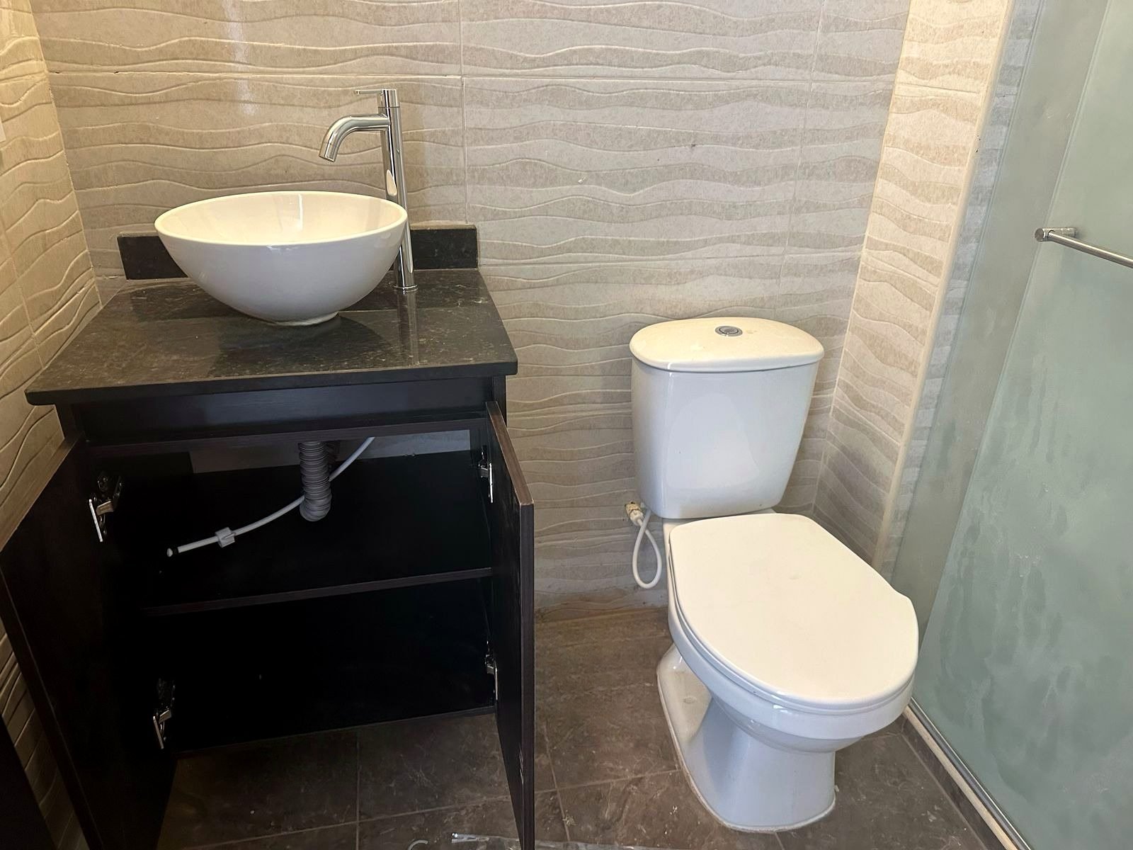 Baño terminado con enchape, mueble y sanitario
