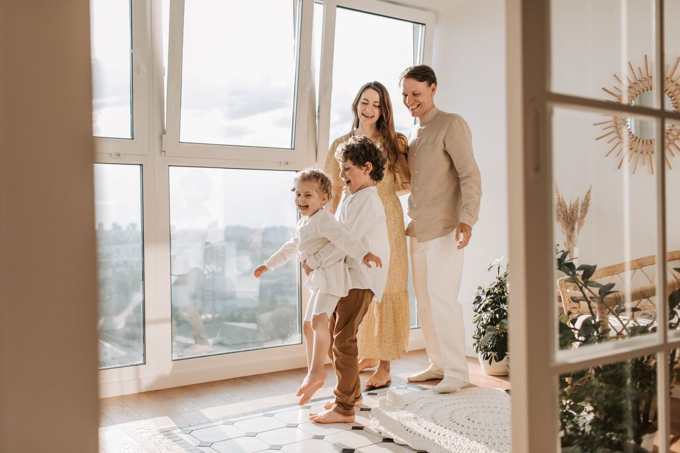 Familia feliz disfrutando de su apartamento recién remodelado, con grandes ventanales y luz natural