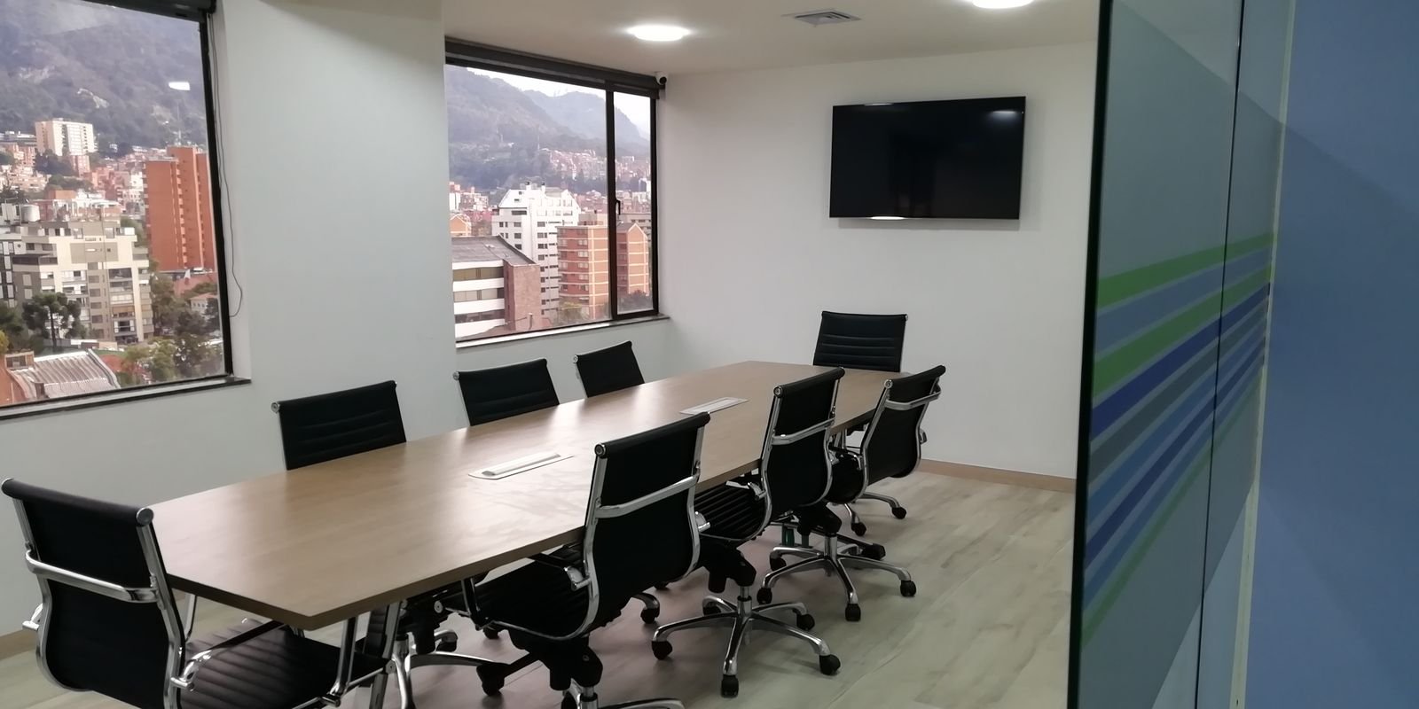 Sala de juntas remodelada con mesa en madera y sillas ejecutivas
